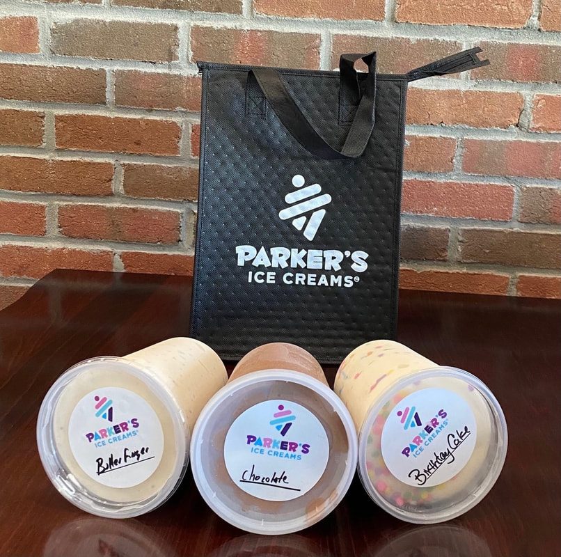 Three hand-labeled pints of Parker's ice cream, Butterfinger, Chocolate and Birthday Cake, in front of a Parker's insulated tote bag against a brick wall.